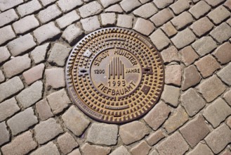 Manhole cover, city of Münster civil engineering, 1200 years 1993, cobblestones, Münster,