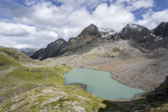 View of the turquoise-blue mountain lake Großer Gradensee, with the peaks of Petzeck and