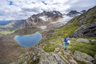 Mountaineer on hiking trail in dramatic high mountain landscape, view of mountains with mountain