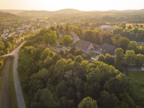 A village view from above with church and half-timbered houses on a tree-covered hill, event and