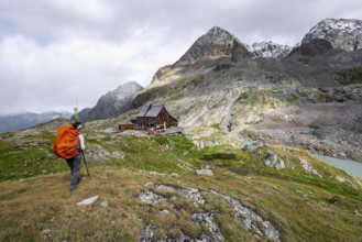 Mountaineer in front of mountain hut Adolf-Nossberger-Hütte, mountain landscape with rocky mountain