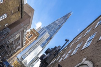 Low angle view of the shard skyscraper dominating the skyline above traditional brick buildings in