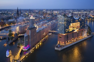 Aerial view of the Elbphilharmonie at blue hour with illuminated windows and view over the