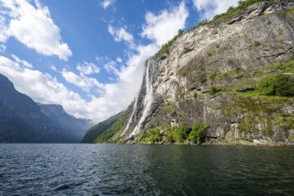 Geirangerfjord at the waterfall The Seven Sisters, tip of a red kayak in the fjord, atmospheric