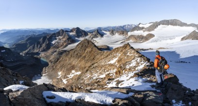 Mountaineer on a rocky ridge on the Wilder Freiger summit, behind him Signal summit and Becher