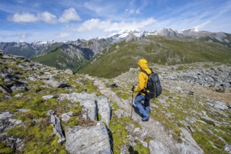 Mountaineers on a hiking trail, view of picturesque mountain landscape with snow-covered summit of