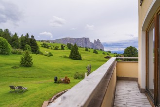 Balcony with a view of a wide green landscape with mountains and clouds, Alpe di Siusi, South