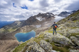 Mountaineer in front of dramatic high mountain landscape, view of mountain lake Vogelhüttensee and