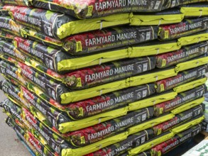 Farmyard manure bags stacked up at Lowden garden centre, Wiltshire, England, UK