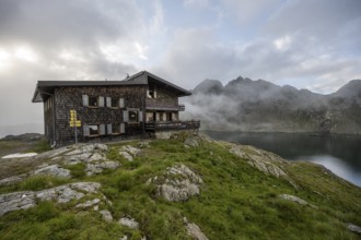 Mountain hut Wangenitzseehütte, cloudy mountain landscape with mountain lake Wangenitzsee, Wiener