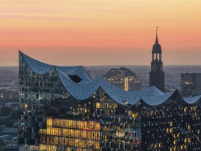 Aerial view of the Elbphilharmonie at sunset with illuminated windows and view over Hamburg and the
