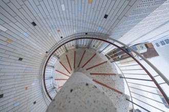 A modern spiral staircase with colourful tiles and bright lighting in a round shape, historical art