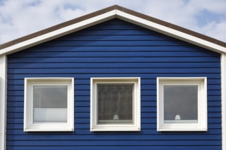 Blue lobster shack, wooden façade with three windows, façade detail in the harbour, Heligoland,