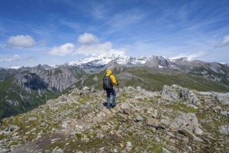 Mountaineers on a hiking trail, view of picturesque mountain landscape with snow-covered summit of