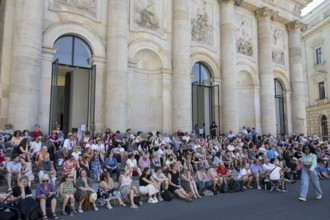 Visitors sit in the shade in front of St Hedwig's Cathedral without being able to see anything at