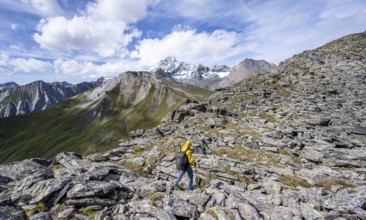 Mountaineer in boulder terrain, at the summit of Kastenegg, view of picturesque mountain landscape