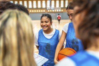 Happy basketball players gathering in a gym, discussing game strategies and fostering teamwork