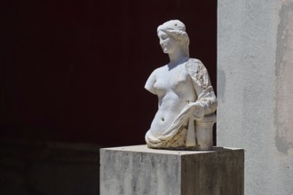©Udo Rein, An ancient marble bust with damaged arms stands on a pedestal in the shade, Aphrodite,