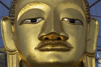 Face of a 32 metre high standing Buddha decorated with glass mosaics and 24-carat gold, Luang Pho