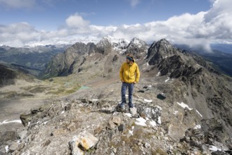 Mountaineer in rocky mountain landscape, at the summit of Keeskopf, behind summit of Petzeck, Hoher