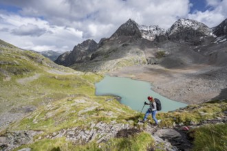 Mountaineer on hiking trail in mountain landscape, view of turquoise-blue mountain lake Großer