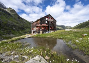 Elberfelderhütte mountain hut with small lake and cotton grass, in the upper Gössnitz valley,