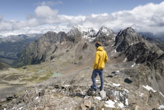 Mountaineer in rocky mountain landscape, at the summit of Keeskopf, behind summit of Petzeck, Hoher