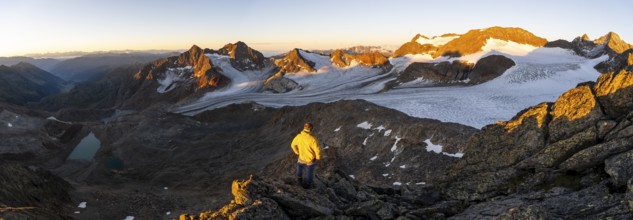 Mountaineers in front of a picturesque high mountain landscape at sunrise with alpenglow, blue