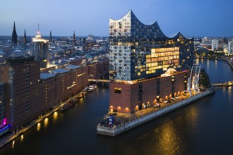Aerial view of the Elbphilharmonie at blue hour with illuminated windows and view over the