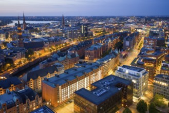 Aerial view of the Speicherstadt Hamburg at blue hour with churches and Alster in the background,