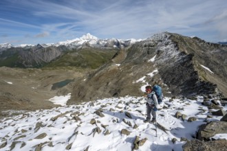Mountaineer in boulder terrain with fresh snow in summer, ascent to the summit Böses Weibl, view of