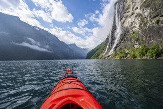 Kayak trip on the Geirangerfjord at the waterfall The Seven Sisters, tip of a red kayak in the