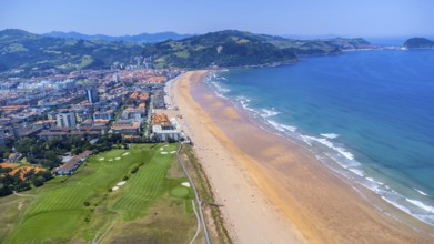 Aerial view of zarautz, gipuzkoa, showcasing the golden sands, turquoise waters, and green hills of
