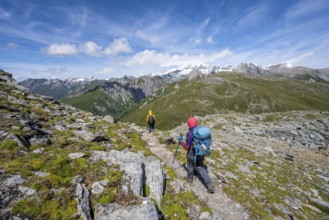 Mountaineers on a hiking trail, view of picturesque mountain landscape with snow-covered summit of