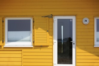 Yellow bungalow, holiday home, wooden house, facade detail with glass door and window, Insel Düne,