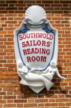 Sign with mermaids on Southwold Sailors Reading Room building, Southwold, Suffolk, England, UK