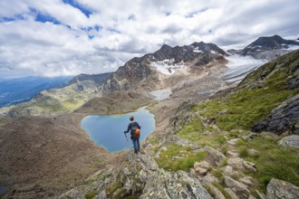 Mountaineer in front of dramatic high mountain landscape, view of mountain lake Vogelhüttensee and