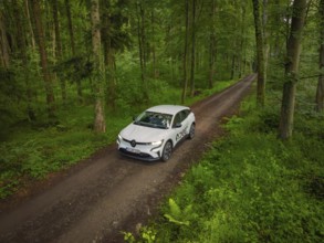 View of the forest from above with car on a road, surrounded by trees, Deer E- CarSharing, Renault