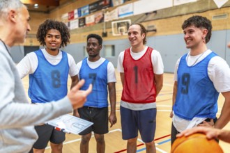 Coach holding clipboard explaining game strategy to his basketball team players wearing training