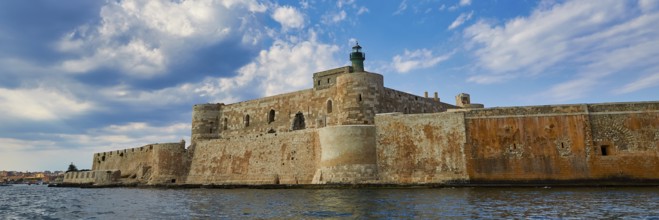 Castello Maniace, sea fortress Maniace, ancient fortress with lighthouse in front of a cloudy sky,