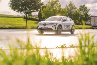 Car driving over a wet road, surrounded by green nature and trees, Deer E- CarSharing, Renault