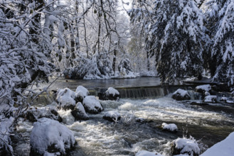 Waterfall at the Eisbach, winter with snow in the southern part of the English Garden, Munich,