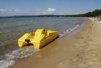 Yellow pedalo on the beach in Varamon, Motala, Sweden, Europe