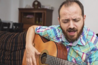 Young man musician playing acoustic guitar
