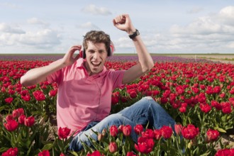 Dutch man sitting in flower fields listeing to cool music