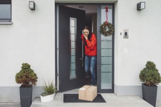 Cheerful young woman excited over a package she just received. Woman getting her christmas gift in