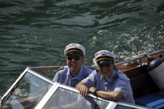 A smiling couple of water-police-officers on the Limmat-River with the major of Zürich City on