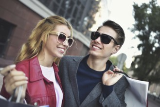 Portrait of a couple with shopping bags in the city.People, sale, love and happiness concept