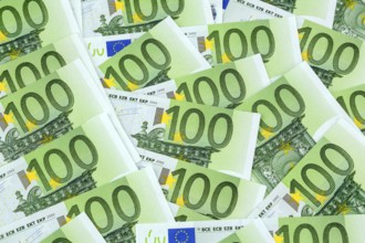 Many one hundred euro banknotes lying next to each other. Symbolic photo for wealth and investment