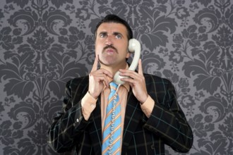 Businessman with scared expression talking by telephone with retro mustache